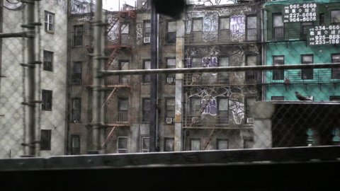 NEW YORK - MAY 4, 2016: gritty tenements buildings covered in graffiti view from moving B Train - subway in NYC. MTA serves the 5 boroughs of the city.