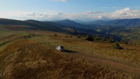 Camera Flies, Suv Rides Through the Mountains of the Carpathians. May 2016 Ukraine Carpathians.green Hills, a Mountain Dirt Road. 4X4 on Sunny Ridges. Evening Summer. Travelling by Car