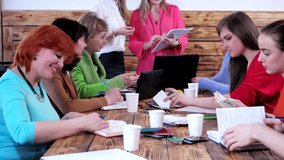 staff drinking coffee and writing plan at meeting in office