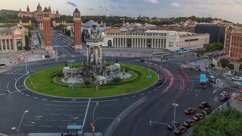 Spanish Square timelapse aerial view at sunset time in Barcelona, Spain. This is the famous place with traffic light trails, fountain and Venetian towers, and National museum at the background.
