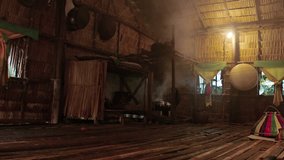 Smoke from a cooking fire fills up the interior of a native. nipa house with bamboo floors in Borneo. Malaysia. Video FullHD