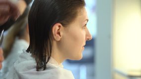 Hairdresser man cuts the young woman hair in barbershop. 4K
