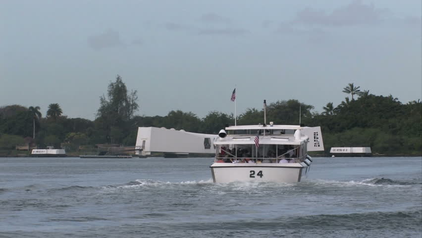 USS Arizona battleship Memorial. Pearl Harbor, Honolulu, Hawaii. Navy tour boat going to memorial. White memorial building floating on top of wreck of battleship. Attack by Japan started US in WW II.