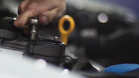 Auto mechanic repair engine at car repair shop. Slow motion
