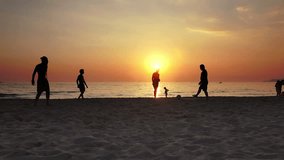 Video of people silhouettes playing football on ocean beach sunset
