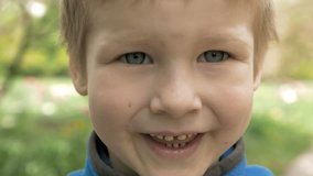 Portrait of smiley and happy boy child looking straight at camera. Face closeup. Childhood emotions and facial expressions concept. 4K UHD video footage.