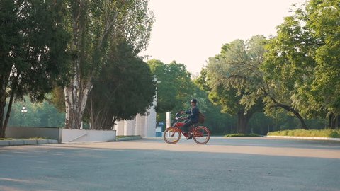 Young woman riding vintage bike in park, slow motion