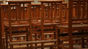 Behind empty cathedral wooden chairs in a row worship building 4K 3840X2160 30fps UltraHD footage - Row of wooden seats in Christian church 4K 2160p UHD video
