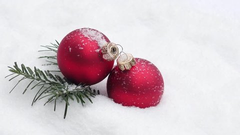 red xmas bauble with fir branch rotated  on snow