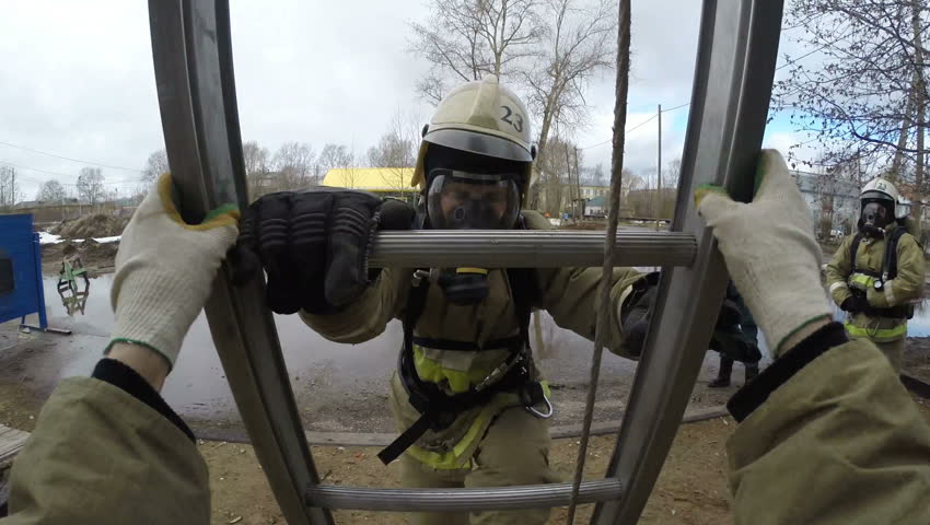 Training firefighters - rescuers.Fire quickly climbs up the fire escape window has 3 floors of educational - training tower. GoPro . 
