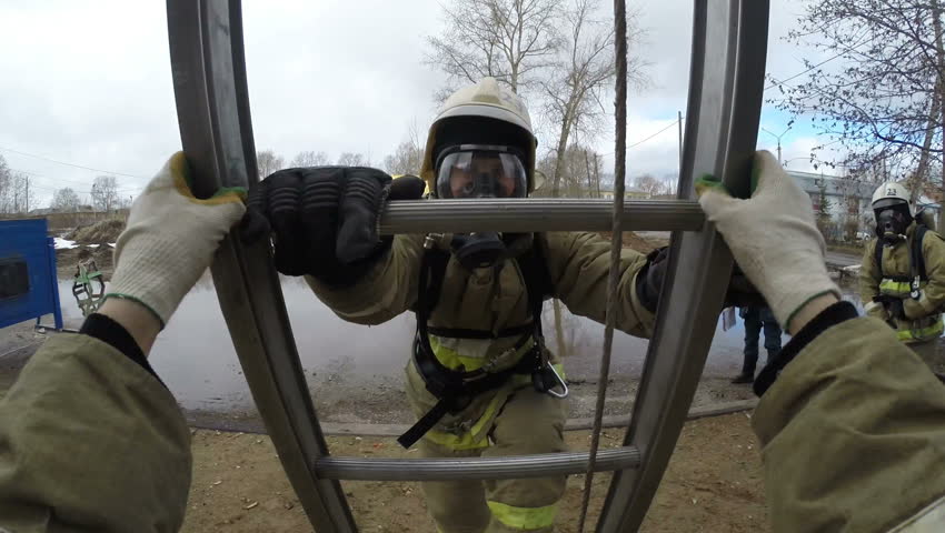 Training firefighters - rescuers.Fire quickly climbs up the fire escape window has 3 floors of educational - training tower. GoPro . 
