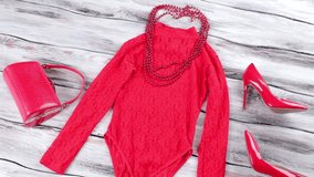 Red bodysuit top and necklace. Bodysuit top and heel shoes. Bright-colored garment on shelf. New items in stock. - Powered by Shutterstock - Get 15% off with code: PIKWIZARD15