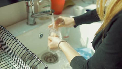 Young woman dish washing
