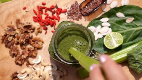 Healthy Eating: Hand Stirring Green Smoothie in Jar Mug
