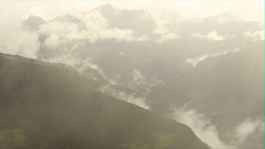 Clouds moving with high speed over the Andes mountains in Ecuador, fading to