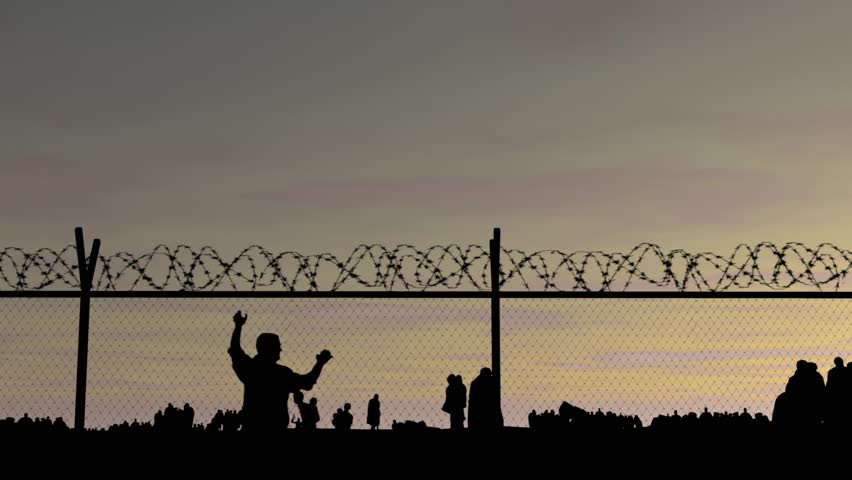 Refugees. Silhouettes of people at sunset, fence with barbed wire and iron bars! People go to the border Royalty-Free Stock Footage #16963783