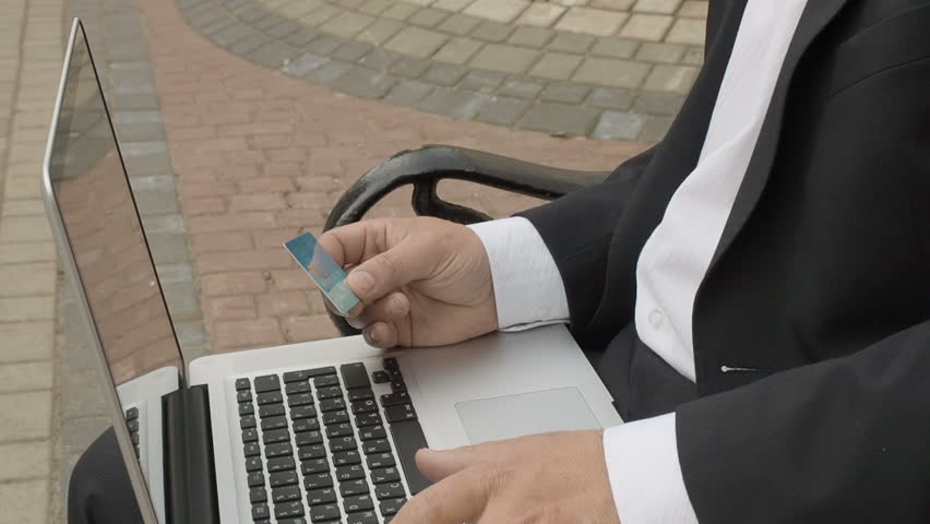 Businessman using his laptop to purchase something online with his credit card