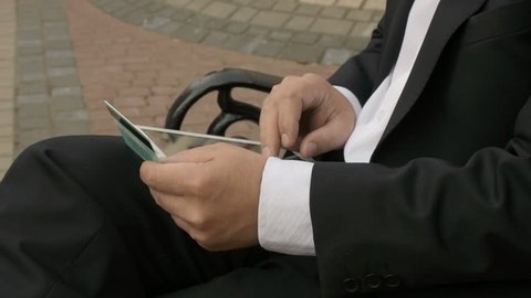Businessman using his tablet PC to purchase something online with his credit card