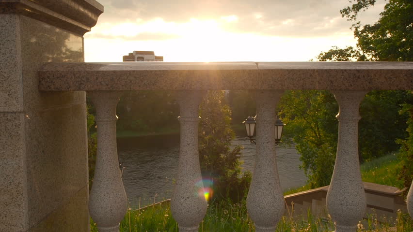 Man in a black business suit near on the embankment of the river sunset