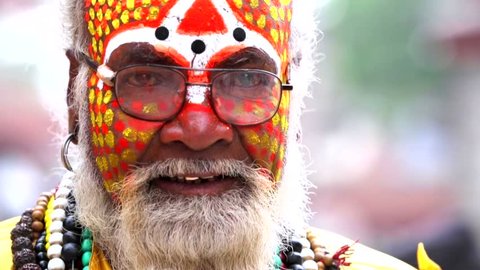 Portrait of smiling sadhu baba (holy man) with colorful face painting at ancient Durbar Square. Nepal, Kathmandu. 