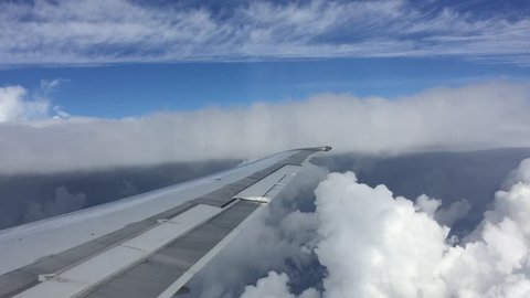 The clouds outside the window. The plane is flying.