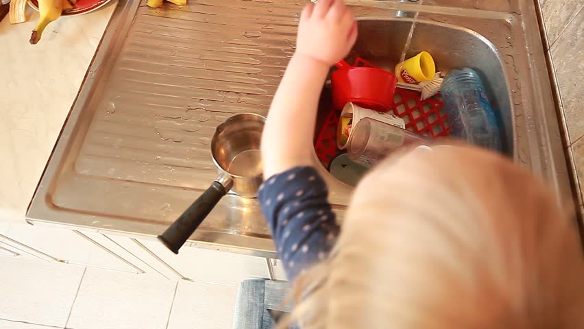 baby in the kitchen washing dishes