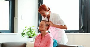 Caucasian nurse doing facial massage to her senior patient in retired home