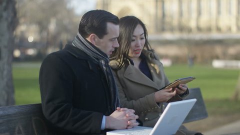 4K Business man & woman using technology at outdoor meeting in the city UK - April, 2016