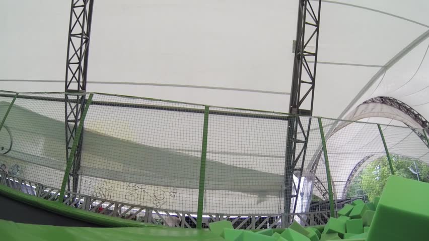 Boy teenager jumps into soft cubes in trampoline center