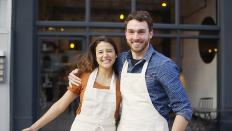 4K Happy business owner couple standing in front of cafe UK - April, 2016
