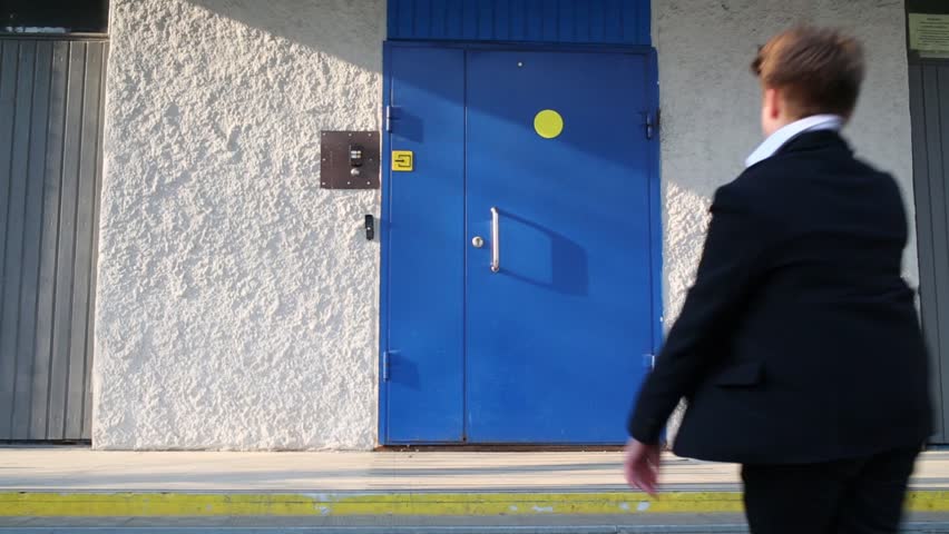 Eight children run into the school building, one of them runs later