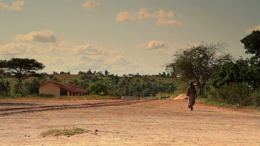 KENYA, AFRICA - CIRCA AUGUST 2010: A woman walking with a baby on her back in
