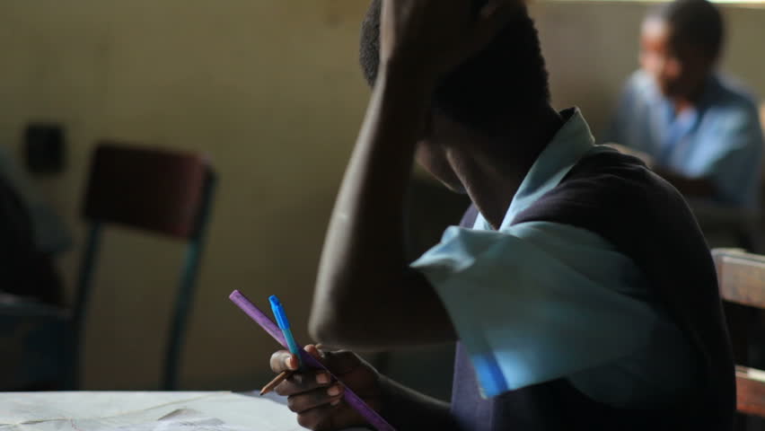 KENYA, AFRICA - CIRCA AUGUST 2010: Student studying, then notices camera at a