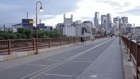 People Walking and Biking across the Stone Arch Bridge in Minneapolis during the Spring at Sunset 4K UHD Timelapse Video Clip