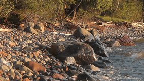Tilting and Panning Across a Rocky Lake Superior Shoreline in the Glow of the Sunset HD Video Clip