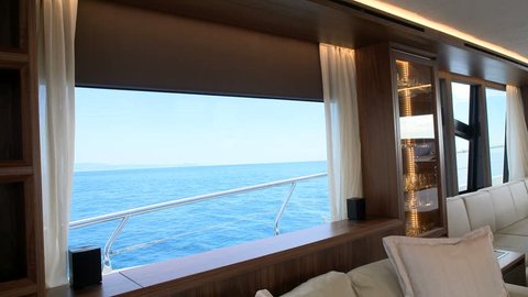 Big window in the salon of a luxury yacht, facing on the sea during navigation
