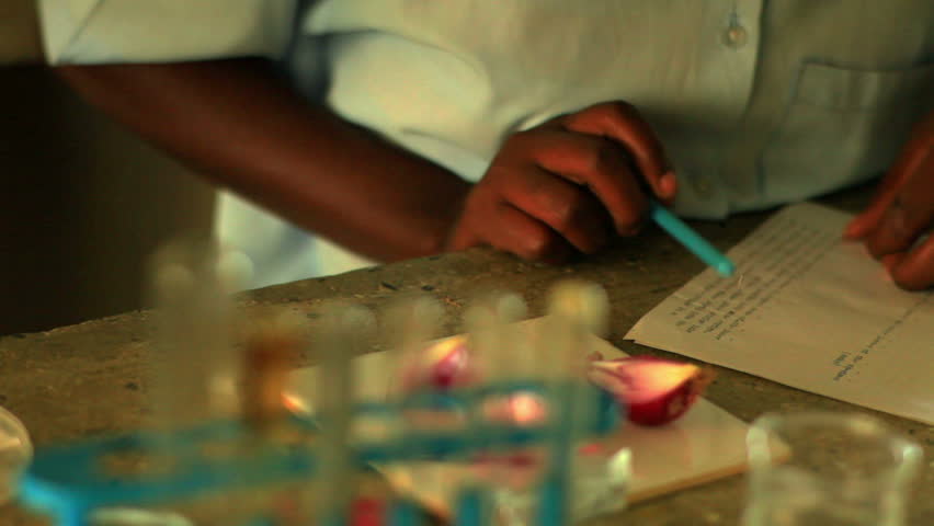 Close up of girl doing chemistry in Kenya, Africa.