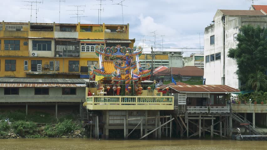 4k, small Chinese temple on the banks of river, colorful Chinese building, high decorated religious construction.