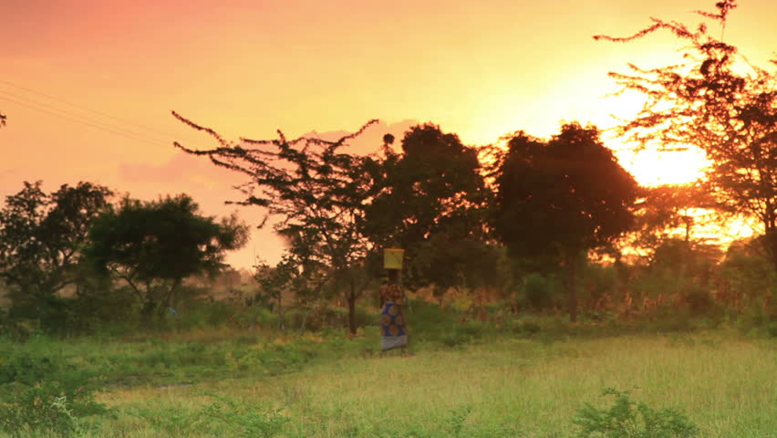 A woman carries water at dawn in a village in Kenya two hours north of the