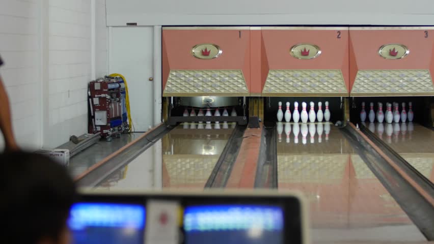 People playing a game of bowling at the small town bowling alley