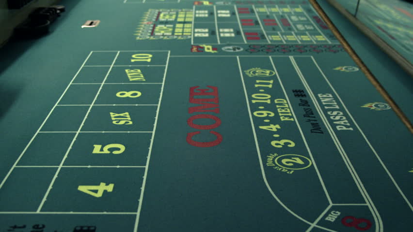 Moving dice across a craps table with the craps stick.