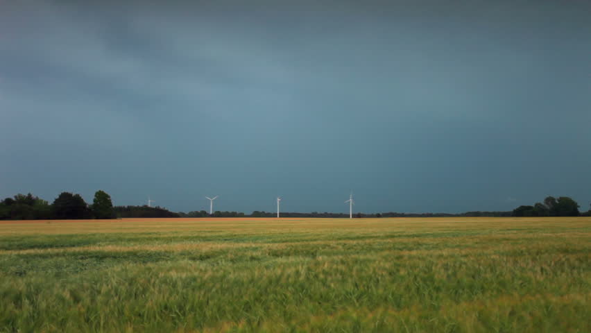 Field in Copenhagen, Denmark. Wind mills, lightning. 