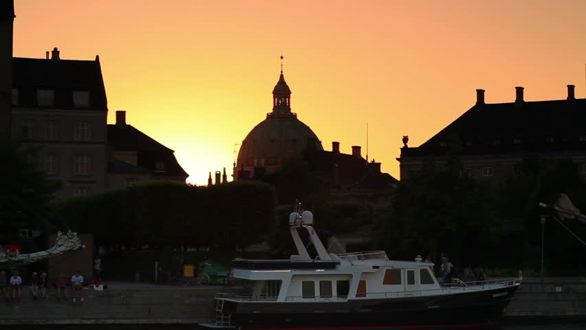 Sunset silhouette of church exterior and boat harbor in Copenhagen, Denmark.