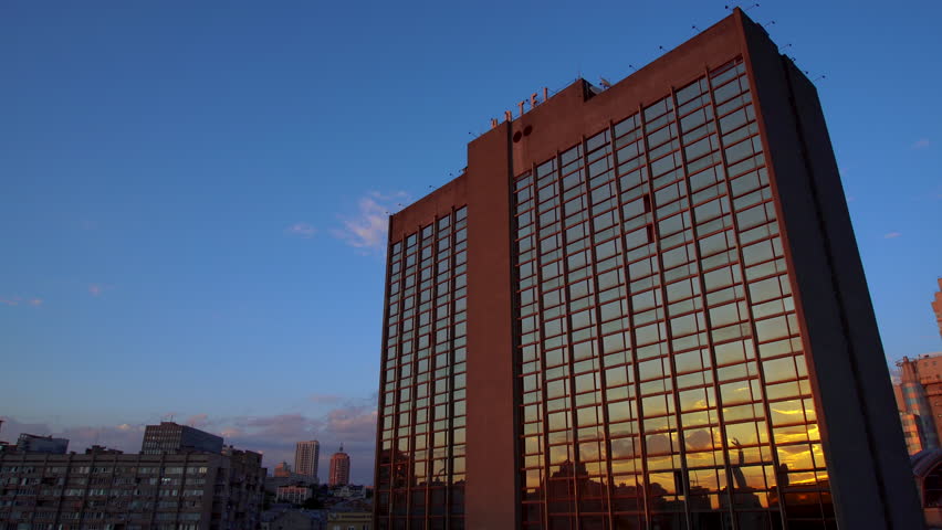 in the Windows of the Tallest Building of the Hotel Reflects the Sunlight From Dusk, Standing on a Background of Blue Sky, the Beautiful Architecture of the City, Industrial Area 4k