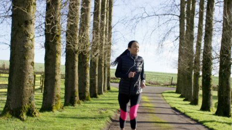 4K Young woman running in the countryside stops to get her breath back. Shot on RED Epic. UK - April, 2016