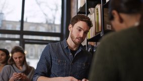 4K Customer in cafe makes payment with credit card while queue of customers wait UK - April, 2016 - Powered by Shutterstock - Get 15% off with code: PIKWIZARD15