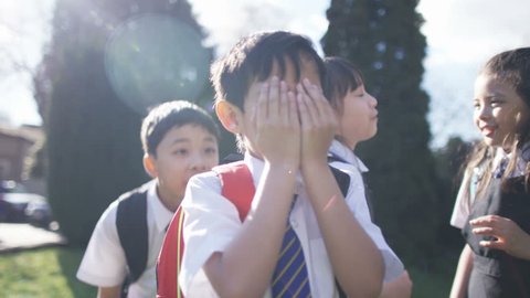 4K Happy young children playing outdoors in school playground UK - April, 2016