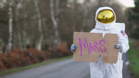 4K Astronaut returned to earth trying to hitch a ride from passing traffic. Shot on RED Epic. UK - April, 2016