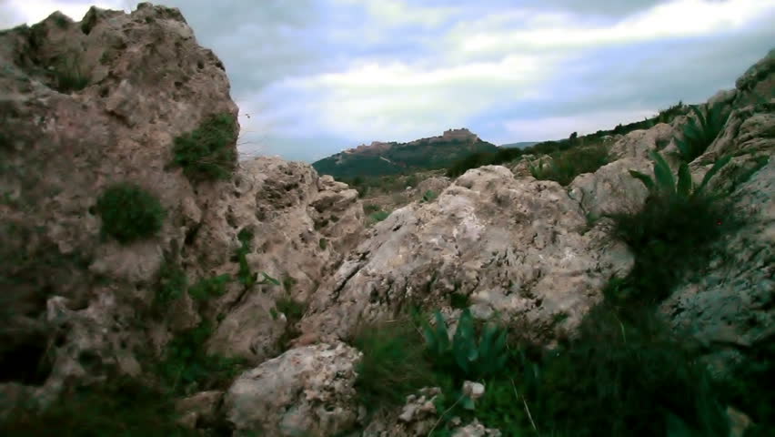 Left to right dolly slider shot between two boulders with Nimrod Fortress in the