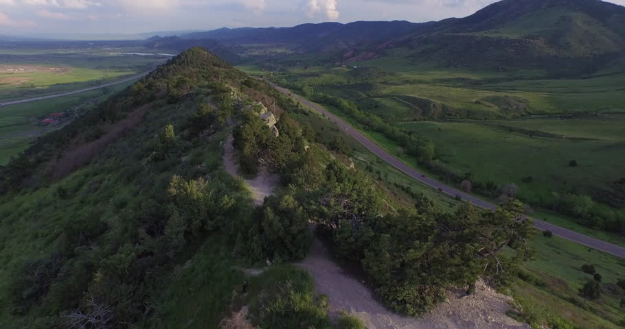 Aerial Ridge Hiking Trail with Highway and Red Rocks in Background - Push In